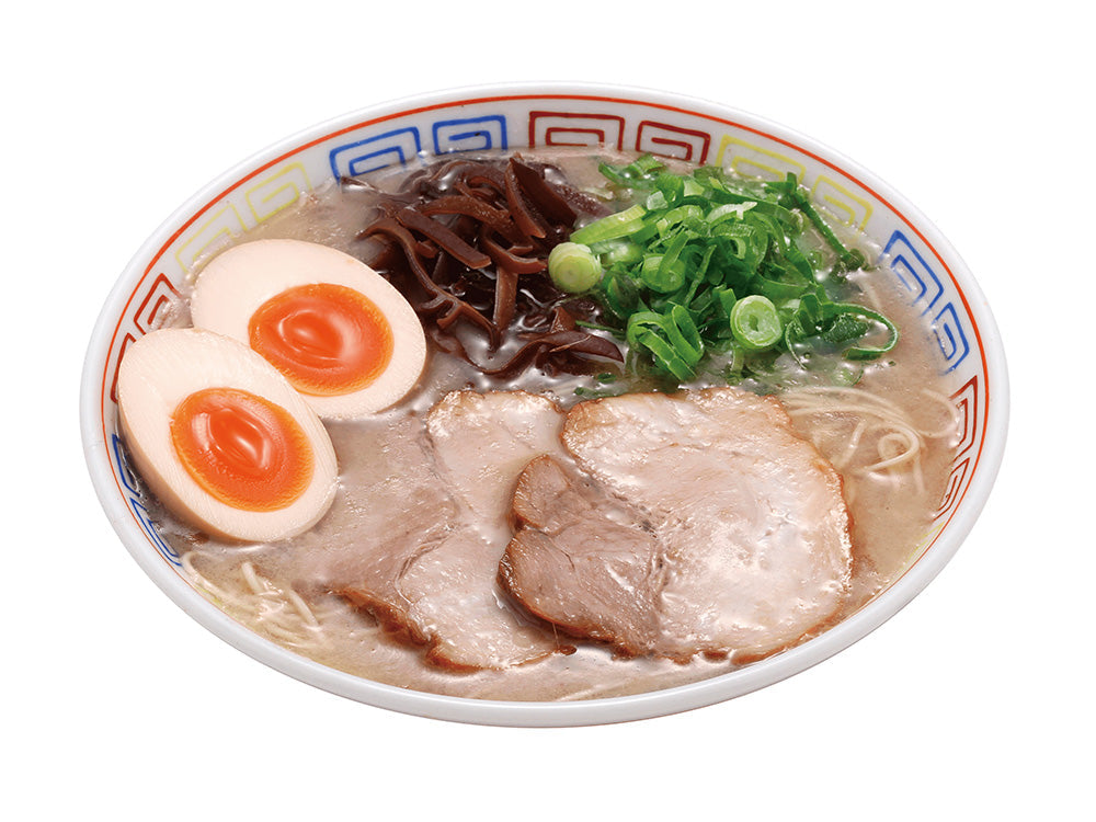 Bowl of Hakata Ramen Daruma Tonkotsu with sliced pork, boiled eggs, green onions, and wood ear mushrooms.