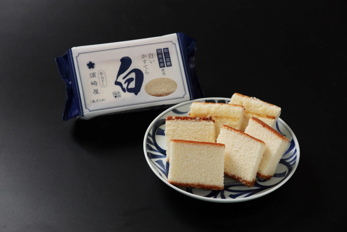 Nagasaki Castella with Wasanbon Sugar, cut-off pieces on a plate, showcasing Suzakiya's traditional Japanese cake in packaging.