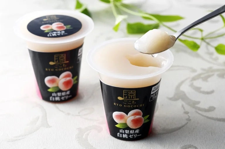 Ryo Gocochi Yamanashi white peach jelly with spoonful, showcasing creamy texture and elegant packaging.