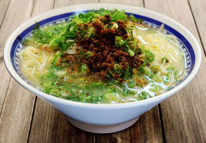 Bowl of Kagoshima Ramen Kuroiwa Tonkotsu with thin noodles and toppings in rich pork bone broth.