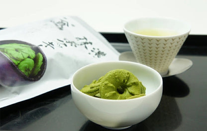 Bowl of rich matcha cookies next to a cup of green tea, showcasing crispy texture and matcha flavor, allergens: wheat, egg, dairy.