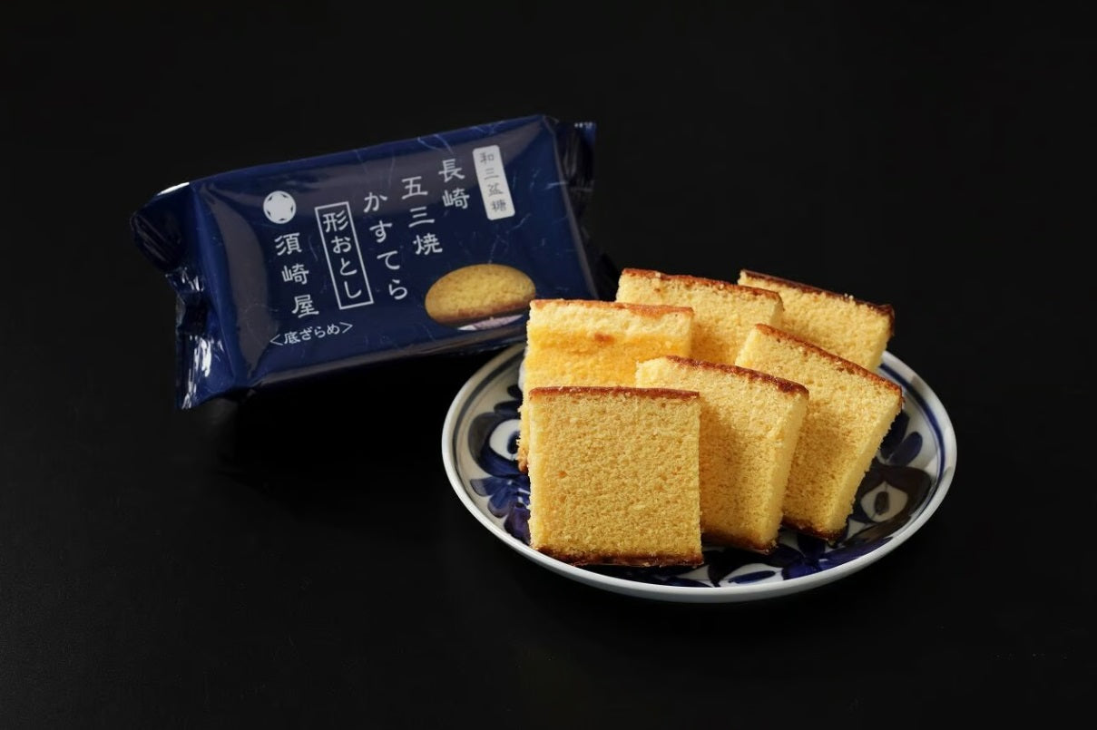 Nagasaki Castella with Wasanbon Sugar End Pieces on a Plate Next to Suzakiya Packaging.