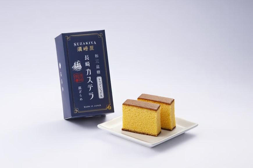 Two slices of Suzakiya Nagasaki Castella with Wasanbon Sugar on a plate beside its packaging.