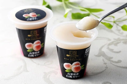 Ryo Gocochi Yamanashi white peach jelly with spoonful, showcasing creamy texture and elegant packaging.