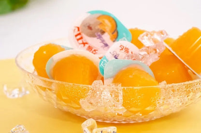 Glass bowl filled with Yubari Melon Jelly Mini pieces on ice, showcasing vibrant orange color; a luxurious treat from Hokkaido.
