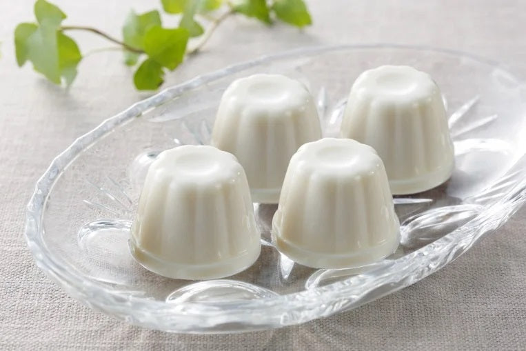 Hokkaido No-Bake Cheese Cake Petit 6P on a glass dish, showcasing creamy texture and made from Hokkaido raw milk. Contains dairy and soybean.