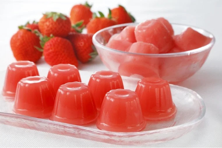 Fukuoka Amaou Strawberry Jelly Mini Box, showcasing bite-sized jellies and fresh strawberries on a white background.