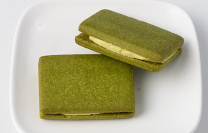 Kyoto Matcha Sable Cookie with White Chocolate Cream, on a plate, featuring luxurious Uji matcha flavor. Allergen info: Wheat, Egg, Dairy, Soy.