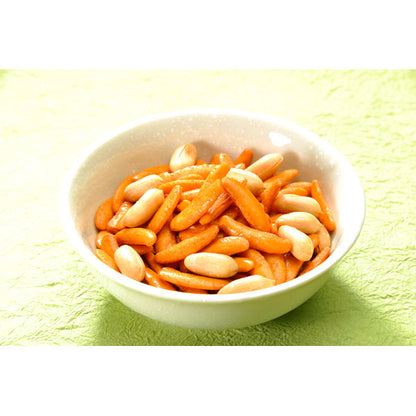 KAMEDA Kaki no Tane rice crackers and peanuts in a bowl with crispy soy sauce flavor, ideal for snacking, on a green background.