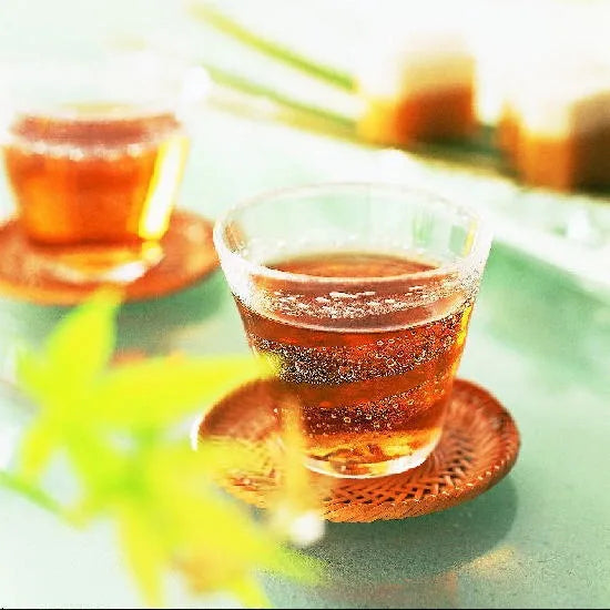Refreshing cups of healthy barley tea for kids, caffeine-free and calorie-free, brewed from Japanese barley, on a sunny table.