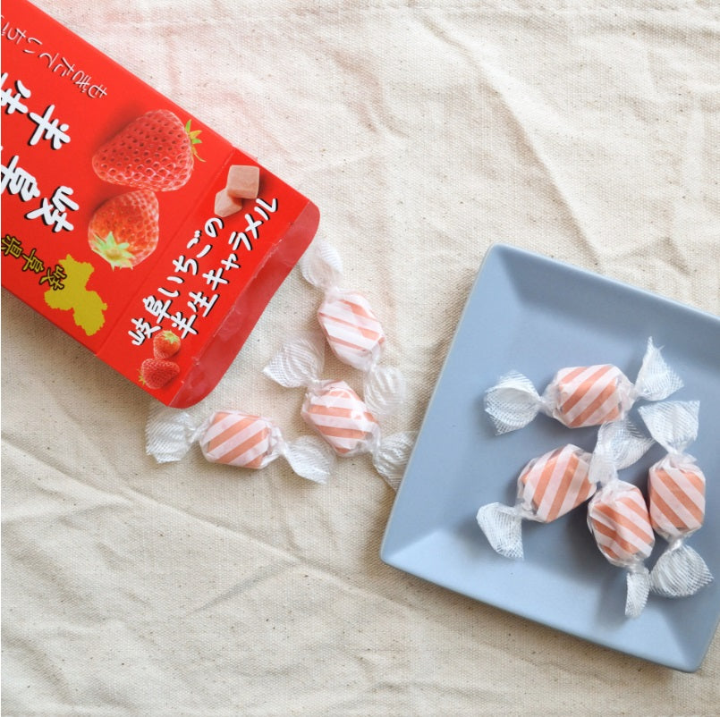 Gifu Strawberry Caramel on a blue plate, showcasing Japanese candies with fresh strawberries from Gifu, known for their rich flavor.
