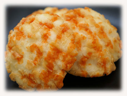 Sea Urchin Rice Crackers with rich sauce, showcasing orange and cream colors on a dark plate. Contains egg, wheat, dairy, squid, soybean.