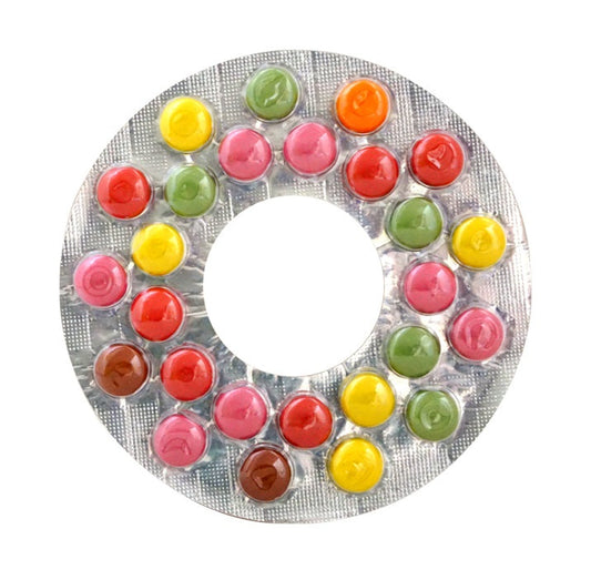 Colorful chocolate candies in circular blister pack, resembling a trap shape, with a mix of red, green, yellow, and pink colors.