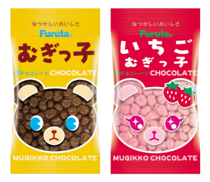 Two packages of Mugikko Chocolate, one with chocolate-coated barley puffs in a yellow bag and another with strawberry flavor in a red bag.