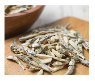 Almond Fish snack with seasoned small fish and roasted almonds on a wooden board, perfect for healthy snacking.