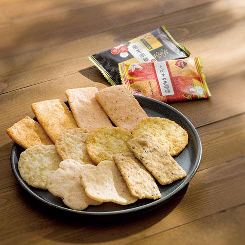 KRN-15 Kenroku no Hana assorted rice crackers on a plate, showcasing a variety of textures, with Kaga Yuzen wrapping in the background.