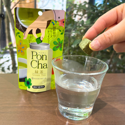 HISHIWAEN PonCha freeze-dried green tea piece dropped into water for instant brewing, pack and glass on table.