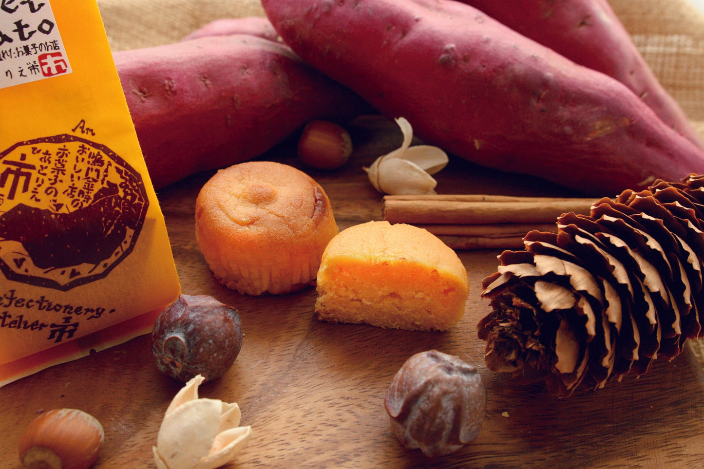 Japanese "Naruto Kintoki" sweet potato cake with ingredients like hazelnuts and cinnamon on a wooden table.