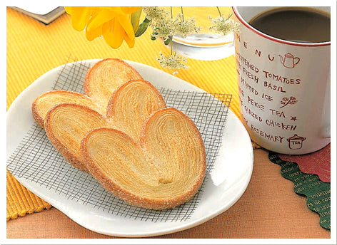 Heart-shaped Genji Pie biscuits on plate with coffee, crispy baked snack with savory flavor. Perfect for adults and children.